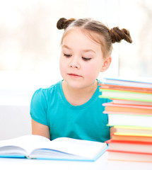 Little girl is reading a book