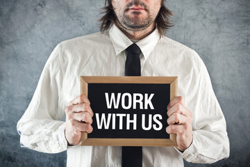 Businessman holding blackboard with WORK WITH US title