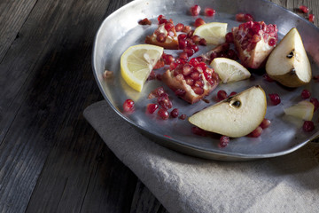 fruits composition pomegranate lemon and pear on wooden table