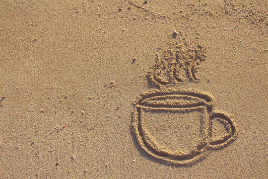 Vintage coffee cup  drawn on sand beach,filtered image