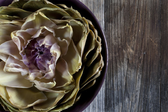 artichoke like lotus flower on bowl on wooden table