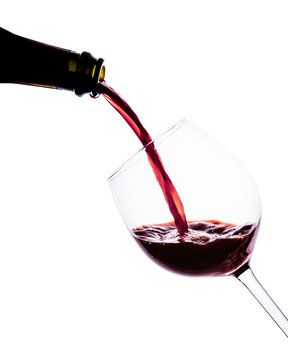 Red wine pouring into wine glass. isolated on white