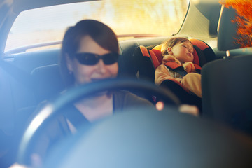 The child in a safety seat near to mother.