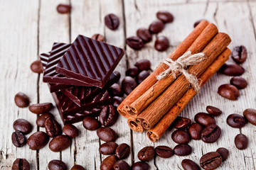 chocolate sweets and coffee beans on rustic wooden background