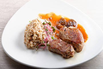 Fototapeta na wymiar Grilled pork tenderloin with prunes and buckwheat