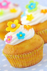 Cupcakes decorated with colourful flowers and buttercream
