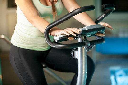 shot of sporty woman riding exercise bike at fitness club