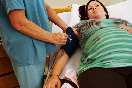 Nurse taking pregnant Mom's blood pressure