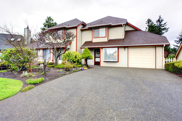 Big house with garage. Siding exterior with red corner trim