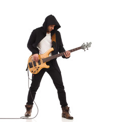 Male guitarist plays the bass giutar.