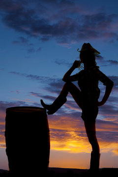 silhouette cowgirl by barrel leg up