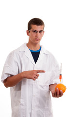 Injection into fruits. Genetically modified fruit with syringe b