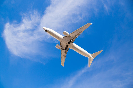 Airplane Flying Overhead With Blue Sky