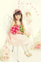 Obraz na płótnie Canvas Adorable little girl with bouquet of tulips