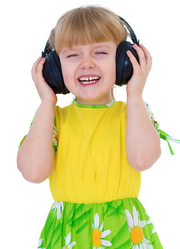 Very musical little girl having fun listening to music through t