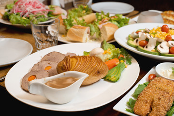 Roast of veal with potatoes with various other plates served