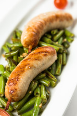 roast sausages on garnish from green haricot
