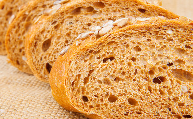 Pieces of bread with seeds on burlap, food photo
