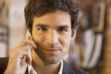 Handsome man calling with a cell phone in coffee bar