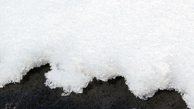 On a black roof snow melts. Time Lapse