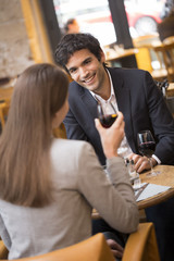 Cheerful couple drinking red wine in French restaurant
