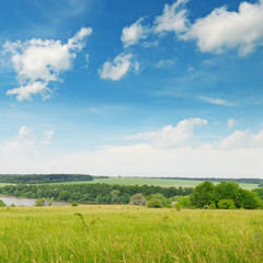 green  field and blue cloudy sky
