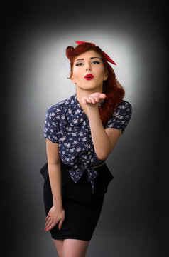 Pin up girl leaning forward and blowing a kiss