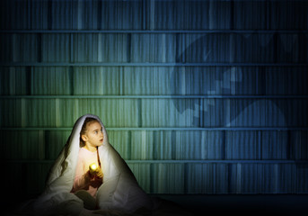 girl under the covers with a flashlight