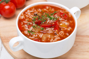 tomato soup with rice, vegetables and herbs, top view