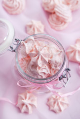 Obraz na płótnie Canvas Pink meringues in a glass jar