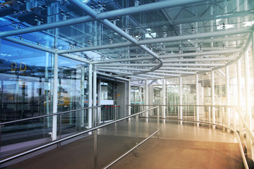 Glass tunnel with sun light British airport interior