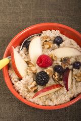 Bowl of steel cut oats served with fresh fruit and honey