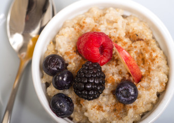 Bowl of steel cut oats served with fresh fruit and honey