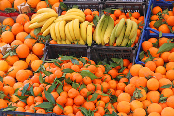 banana yellow and orange tangerines and other fruits for sale at