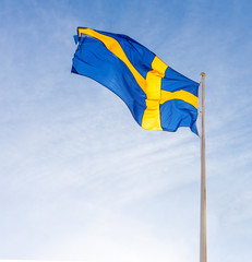 Flag of Sweden waving against blue sky