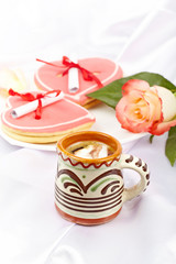 Coffee, heart shaped cookies with notes, rose. Pleasant breakfas