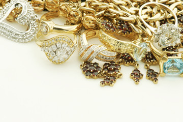 Vintage mixed jewelry pile with gold necklaces,  rings, pendants and diamonds. Copy space below