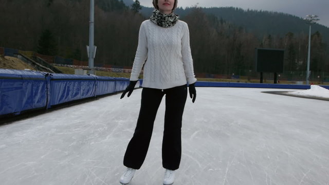 woman figure skating at an open outdoor speed skating rink appro