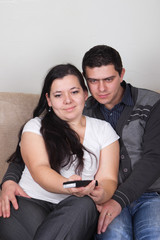 Young couple watching TV at home