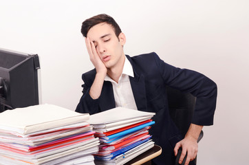 Worried tired business man with a big pile of files to work on.