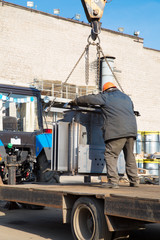 Industrial Worker unloading Complete Transformer Substation