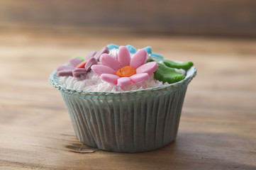beautiful muffins decorated with spring flower on vintage wooden