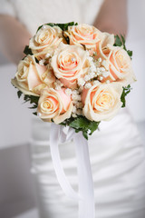 Bride holding wedding bouquet of roses close up