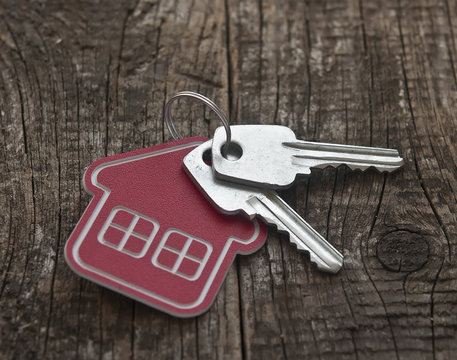 Symbol of the house with silver key on vintage wooden background