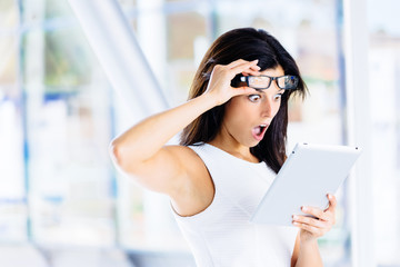 Surprised modern businesswoman with tablet