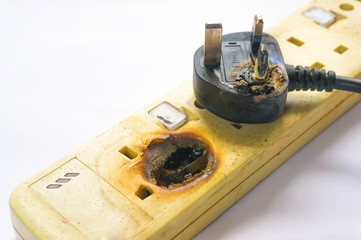 Fire in overloaded power strip isolated white background