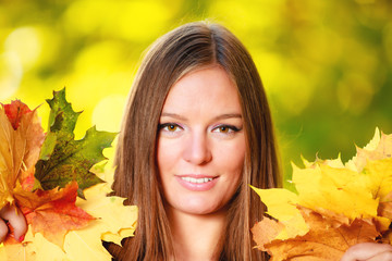 Fall season. Portrait girl woman holding autumnal leaves in park