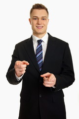 Smiling young businessman at suit shows on you