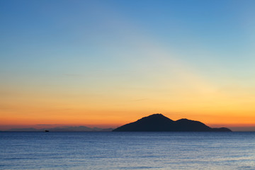 Naklejka na ściany i meble Sunset seascape with small island