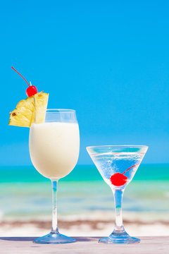picture of two cocktails on a table near beach